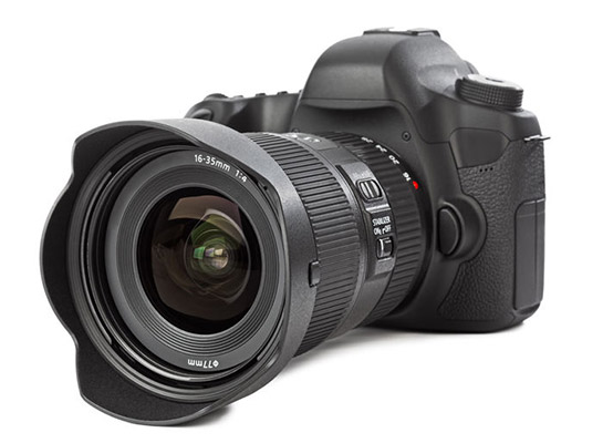 Black digital single-lens reflex camera with a large lens and a lens hood